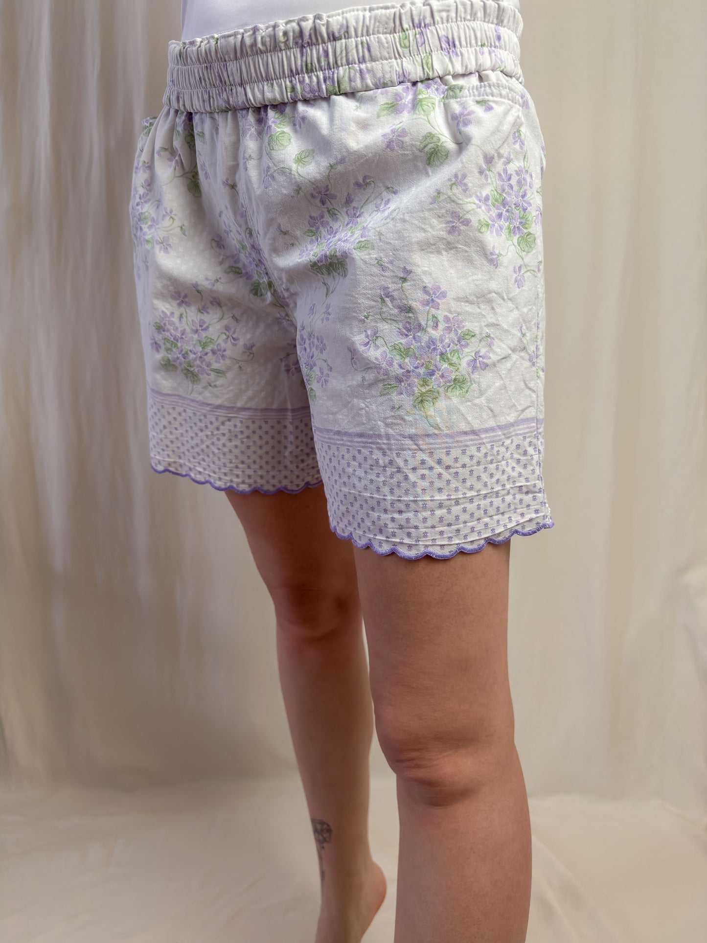 Shorts in white cotton with purple flowers and scallop edges