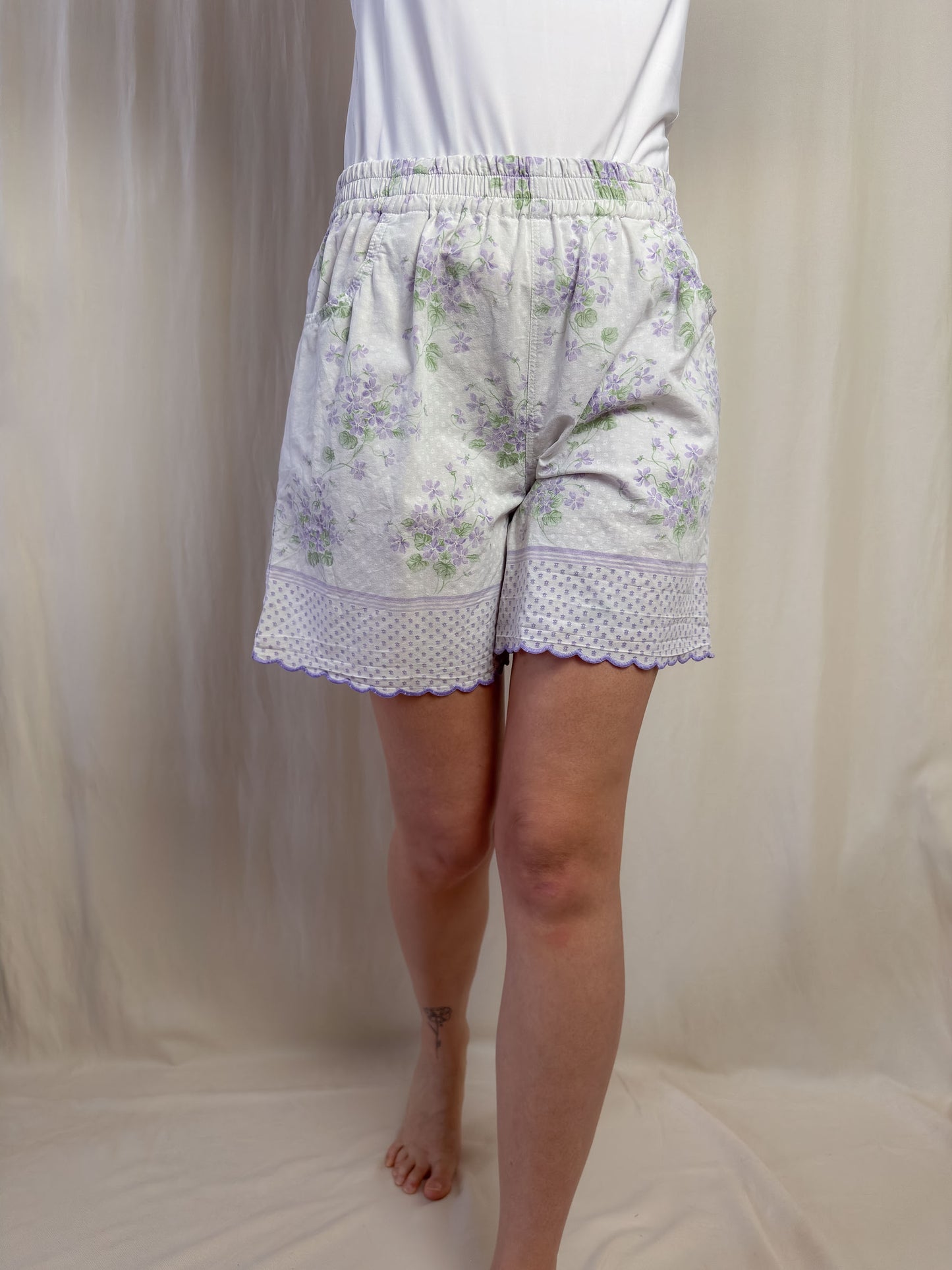 Shorts in white cotton with purple flowers and scallop edges